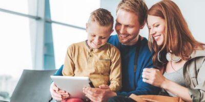 Cheerful family is hanging out with touchpad in lobby